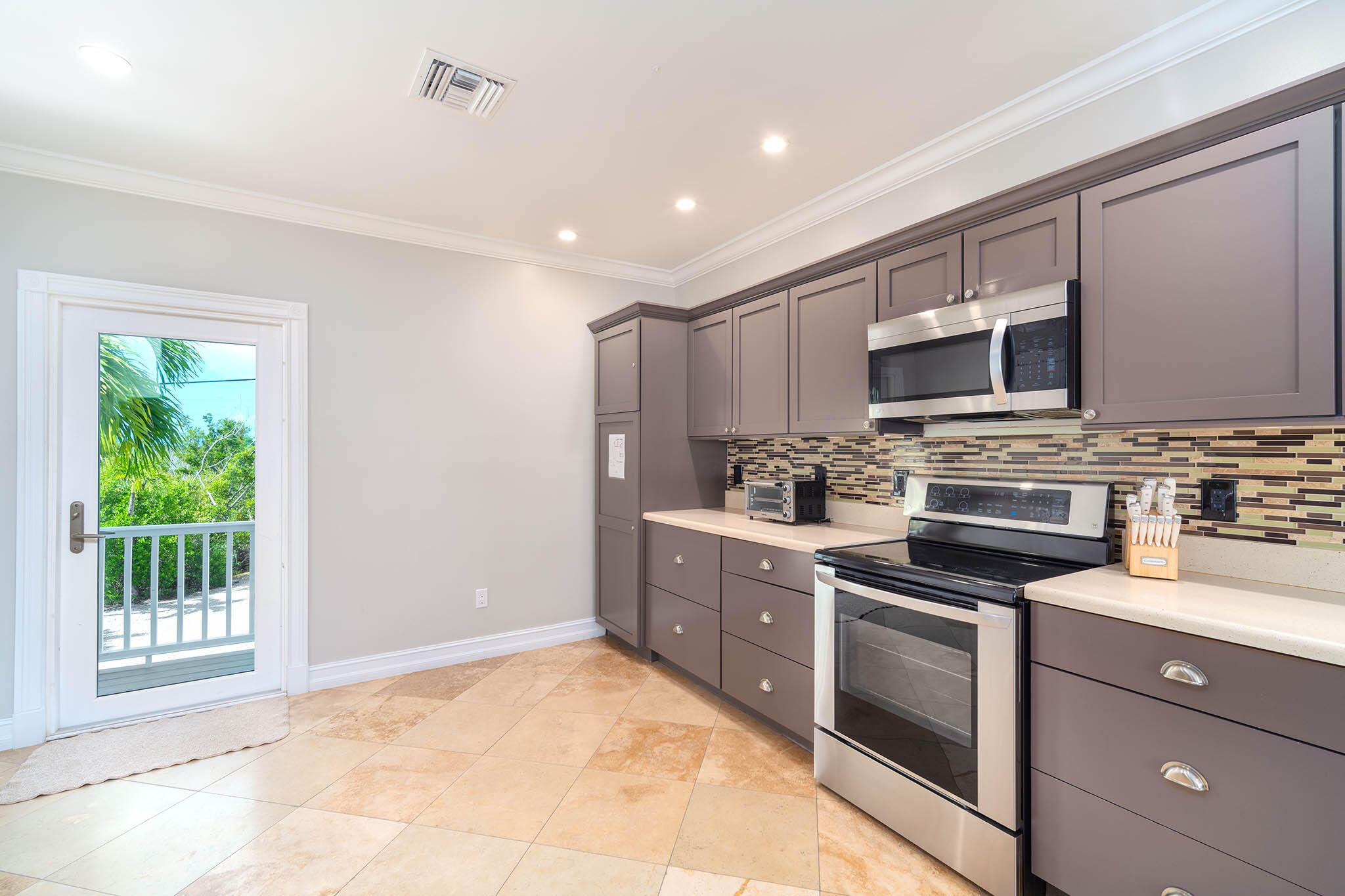 31473 Warner Street Big Pine Key, FL 33043 - Photo 13 of 49 a kitchen with stainless steel appliances granite countertop a stove a sink and a microwave