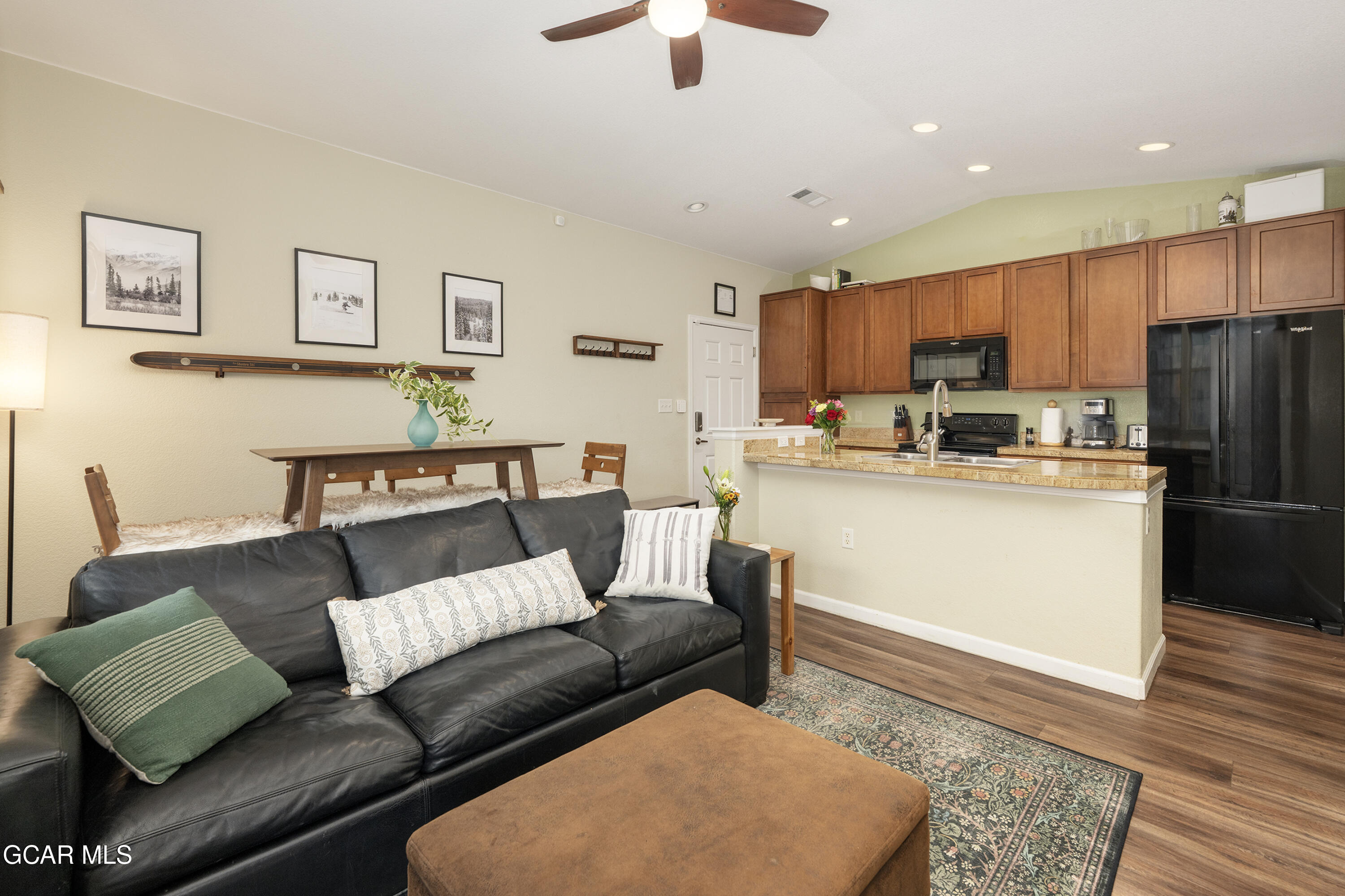 a living room with stainless steel appliances furniture and a rug