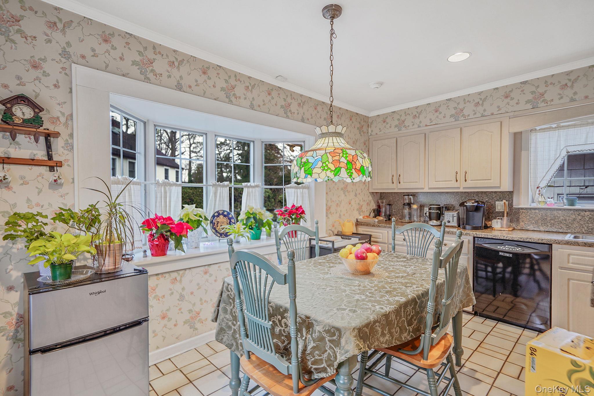 7 Rugby Road Westbury, NY 11590 - Photo 11 of 46 Dining room featuring wallpapered walls, light tile patterned floors, and crown molding