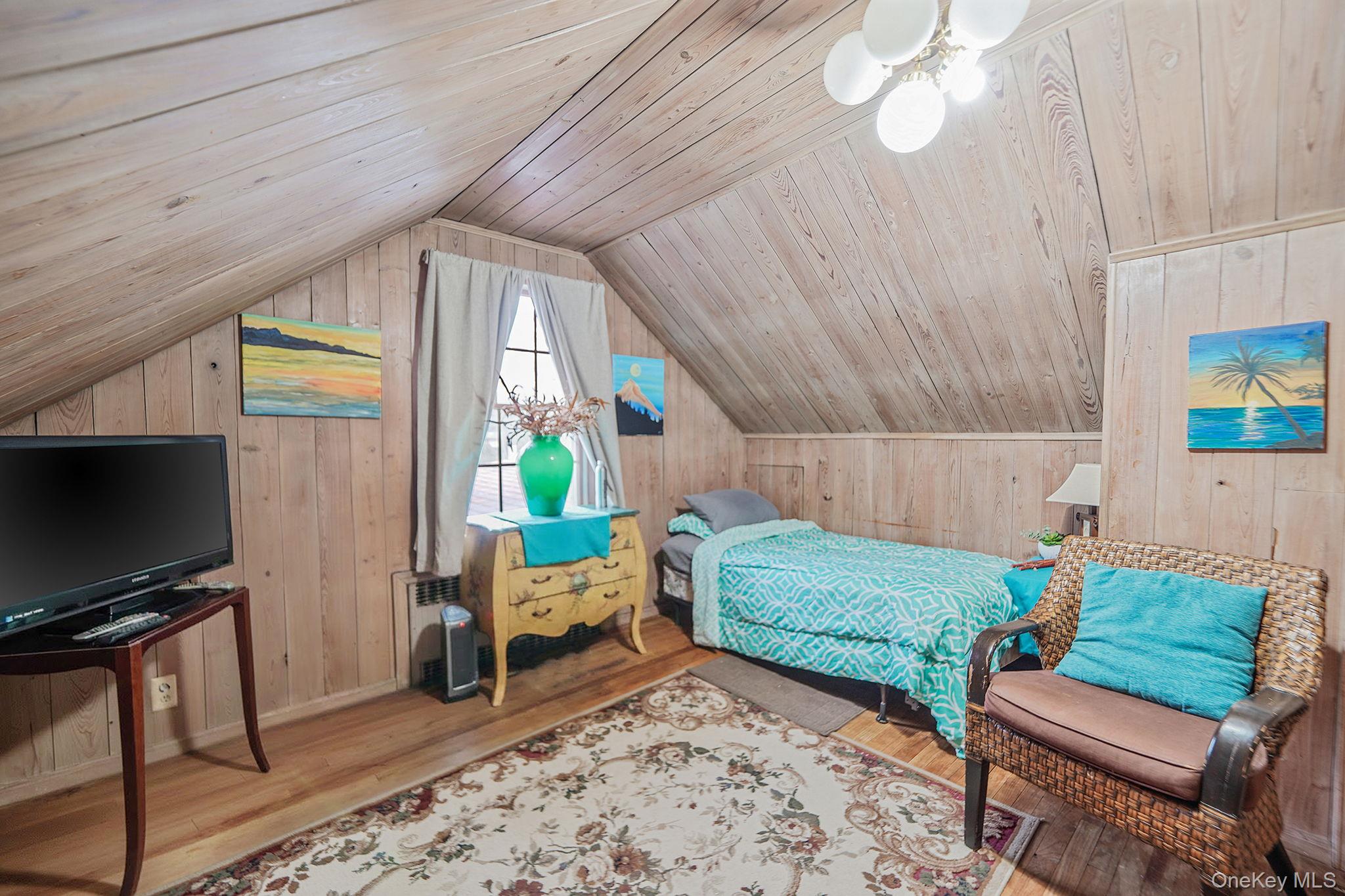 7 Rugby Road Westbury, NY 11590 - Photo 25 of 46 Bedroom with wood walls, wood ceiling, wood finished floors, vaulted ceiling, and a ceiling fan