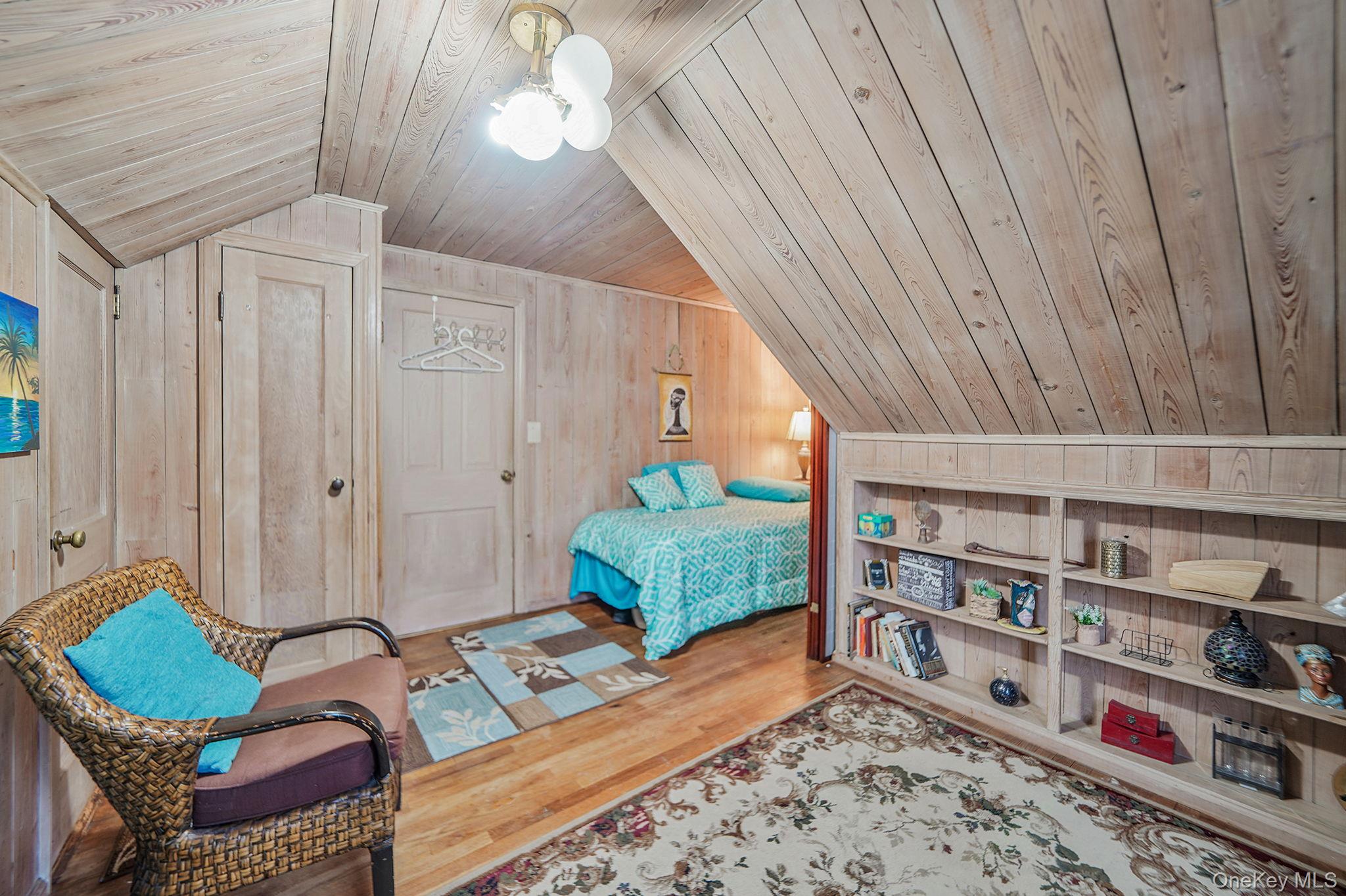 7 Rugby Road Westbury, NY 11590 - Photo 26 of 46 Bedroom featuring vaulted ceiling, wooden walls, wooden ceiling, and wood finished floors