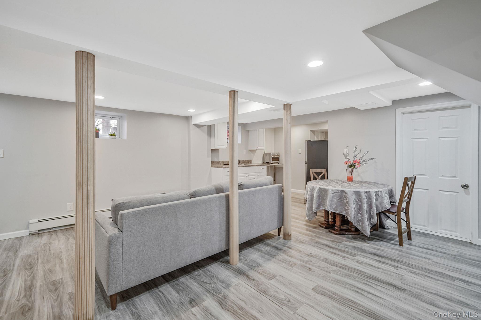 7 Rugby Road Westbury, NY 11590 - Photo 33 of 46 Living area with light wood-type flooring, a baseboard heating unit, and recessed lighting