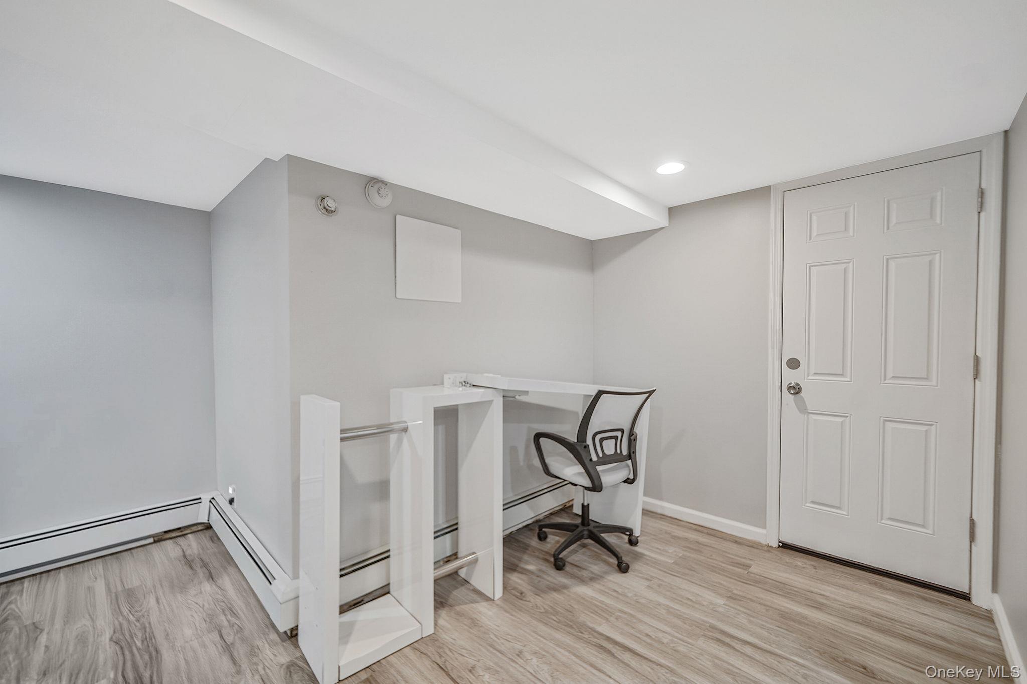 7 Rugby Road Westbury, NY 11590 - Photo 36 of 46 Home office featuring light wood finished floors, a baseboard radiator, and recessed lighting