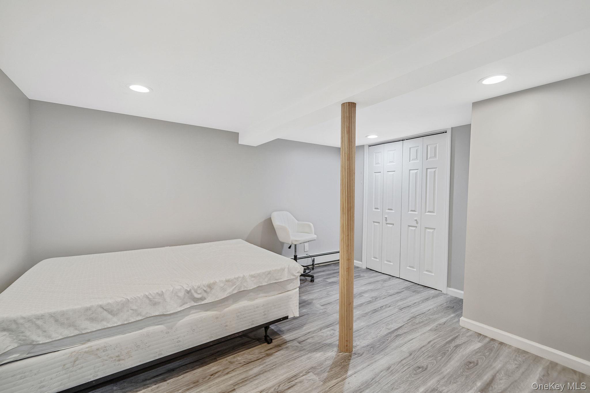 7 Rugby Road Westbury, NY 11590 - Photo 37 of 46 Bedroom with recessed lighting, a closet, light wood-style flooring, and a baseboard radiator