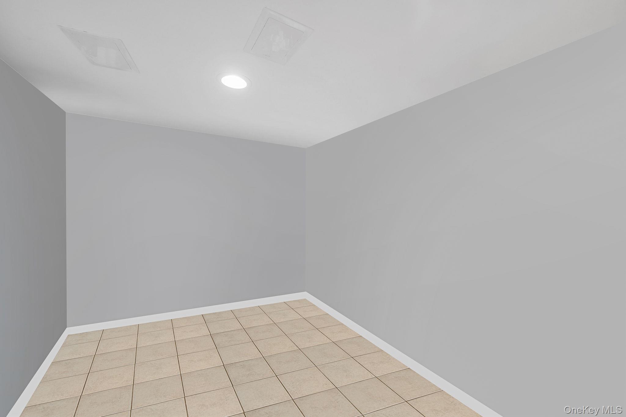 7 Rugby Road Westbury, NY 11590 - Photo 38 of 46 Empty room with light tile patterned floors and recessed lighting