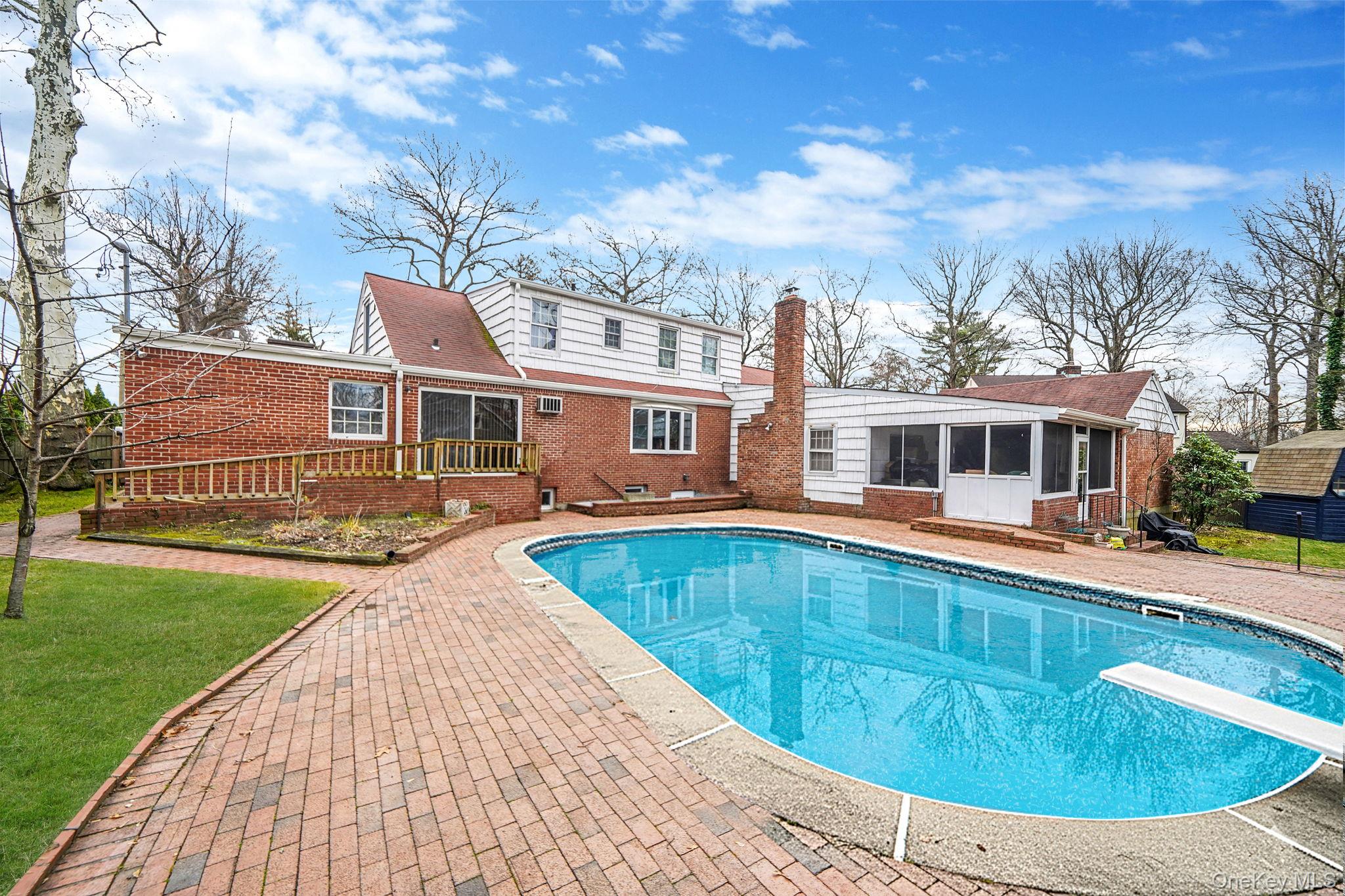 7 Rugby Road Westbury, NY 11590 - Photo 43 of 46 View of pool featuring a sunroom, a diving board, a patio area, and a lawn