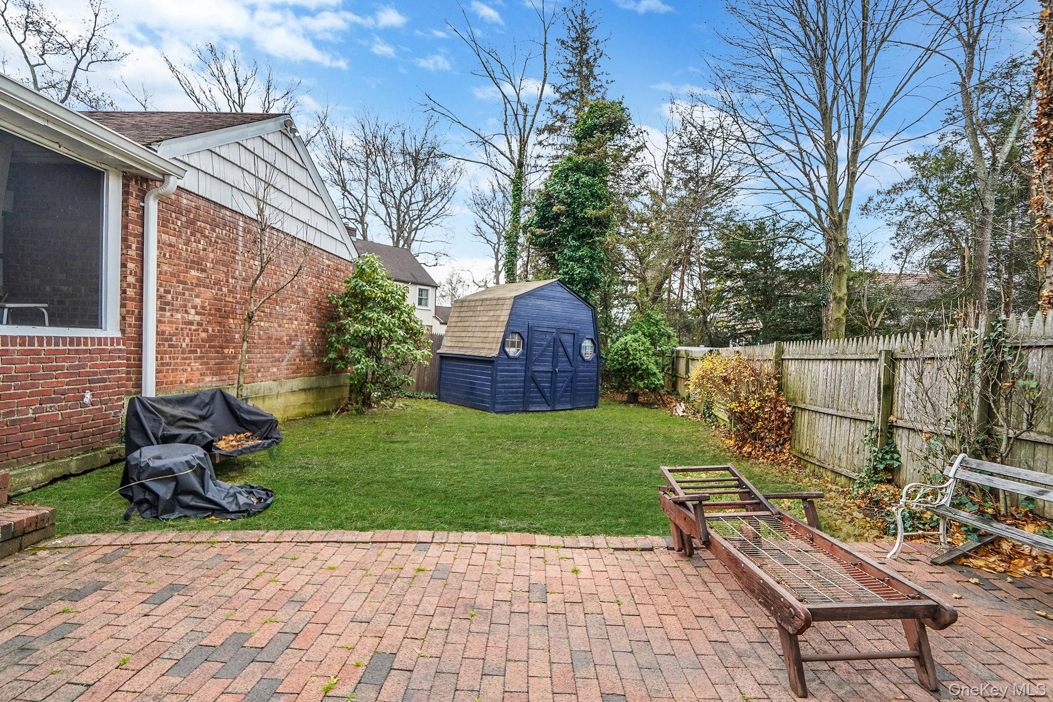 7 Rugby Road Westbury, NY 11590 - Photo 45 of 46 Fenced backyard featuring a storage shed and a patio
