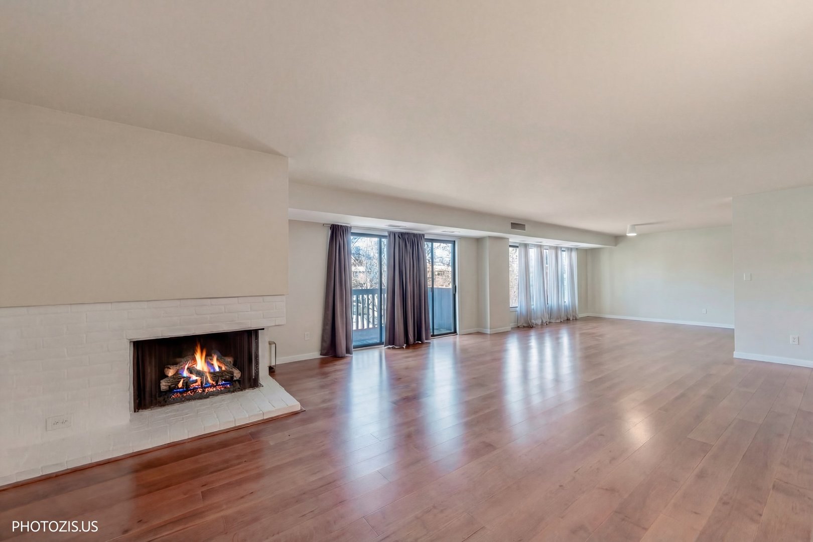1621 Mission Hills Road, Unit 108 Northbrook, IL 60062 - Photo 5 of 22 a view of an empty room with wooden floor fireplace and a window