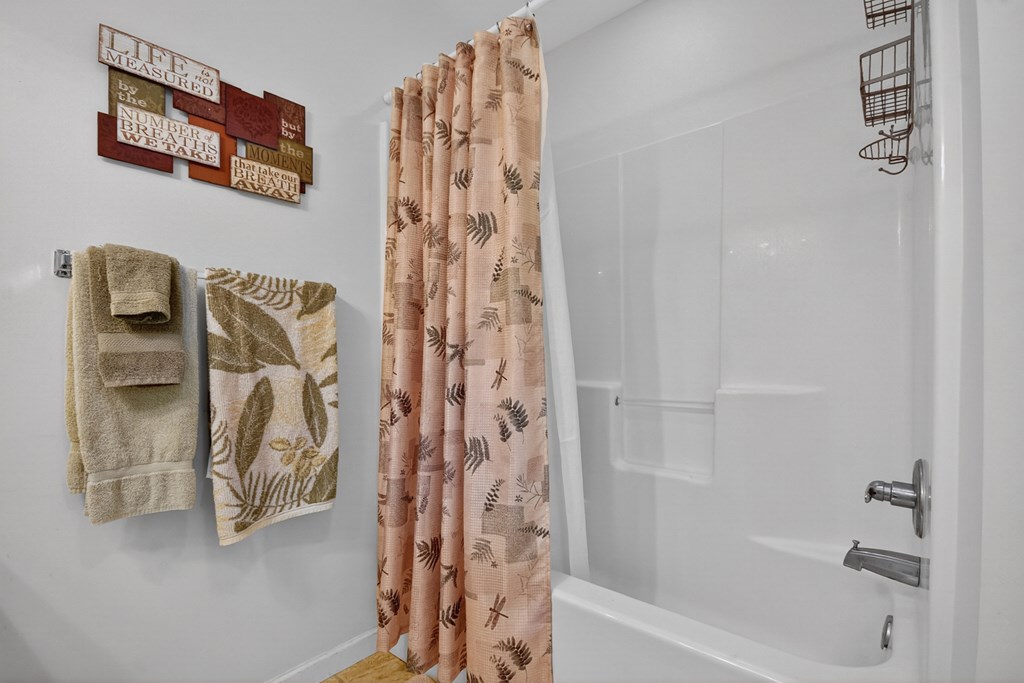 66 Westward Lane Blue Ridge, GA 30513 - Photo 24 of 34 a bathroom with a shower curtain and a tub