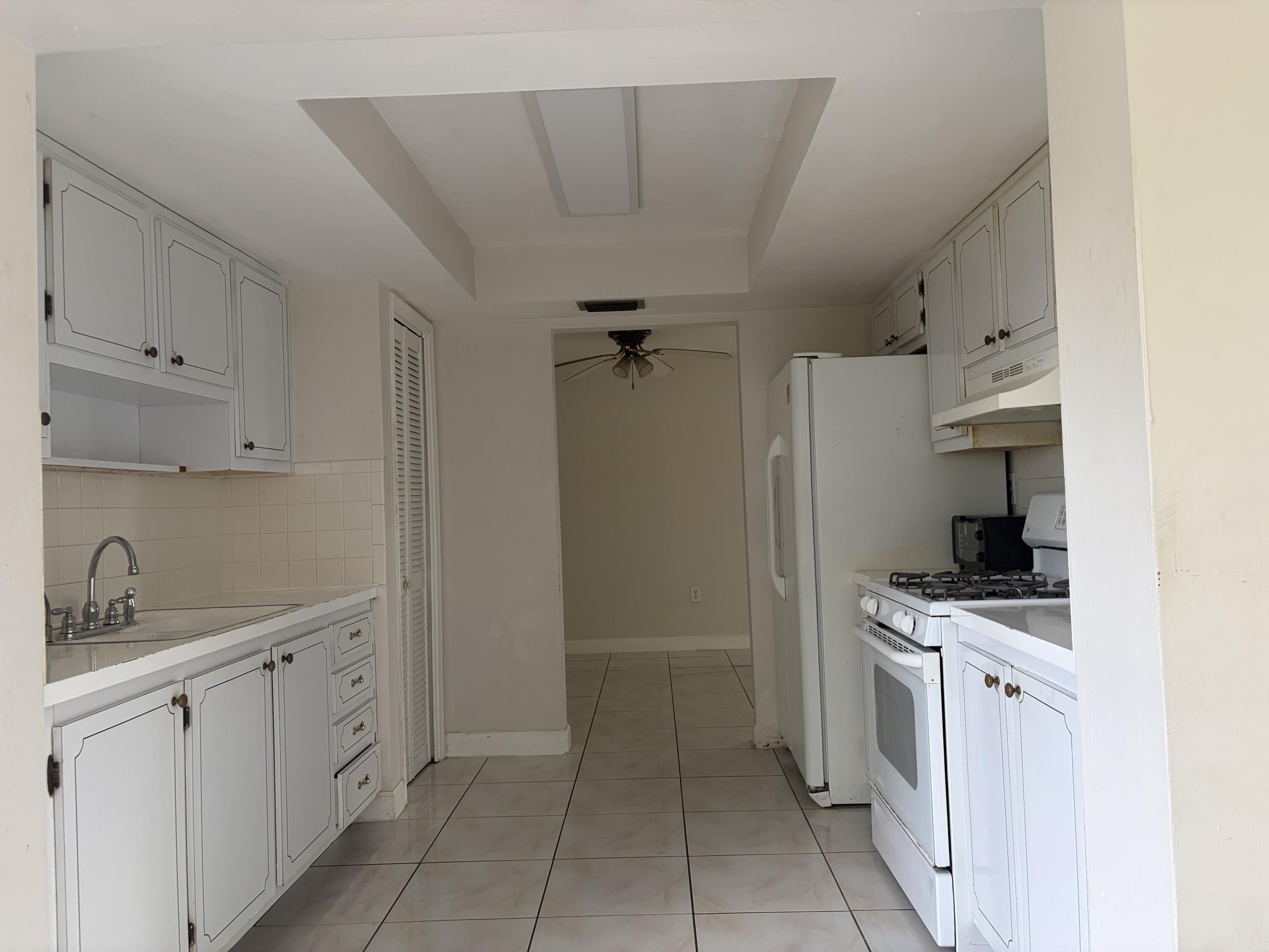 6691 Northwest 30th Street Sunrise, FL 33313 - Photo 12 of 26 a kitchen with white cabinets and appliances