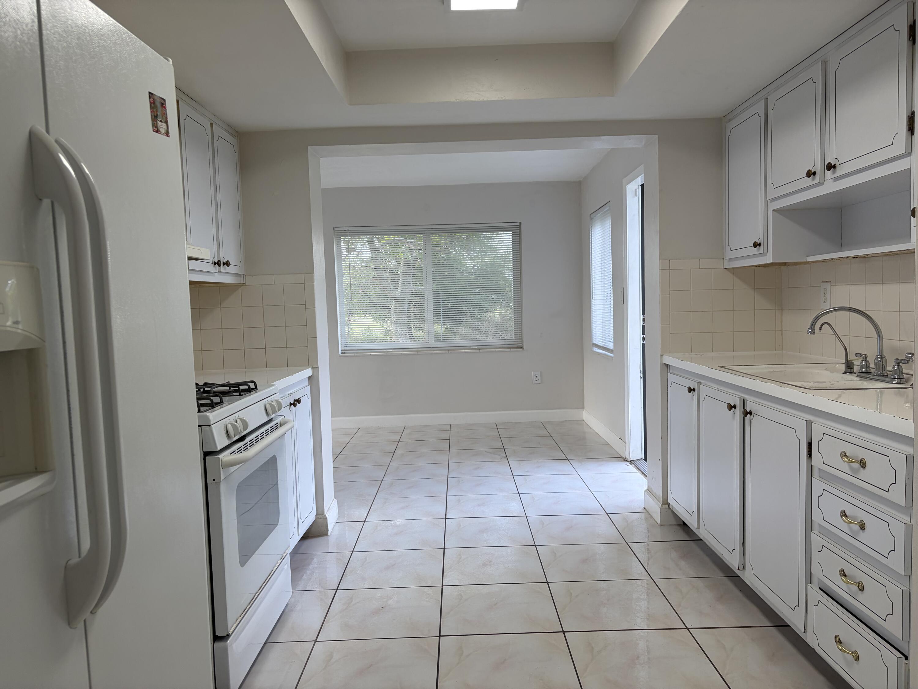 6691 Northwest 30th Street Sunrise, FL 33313 - Photo 13 of 26 a kitchen with granite countertop a refrigerator and a sink
