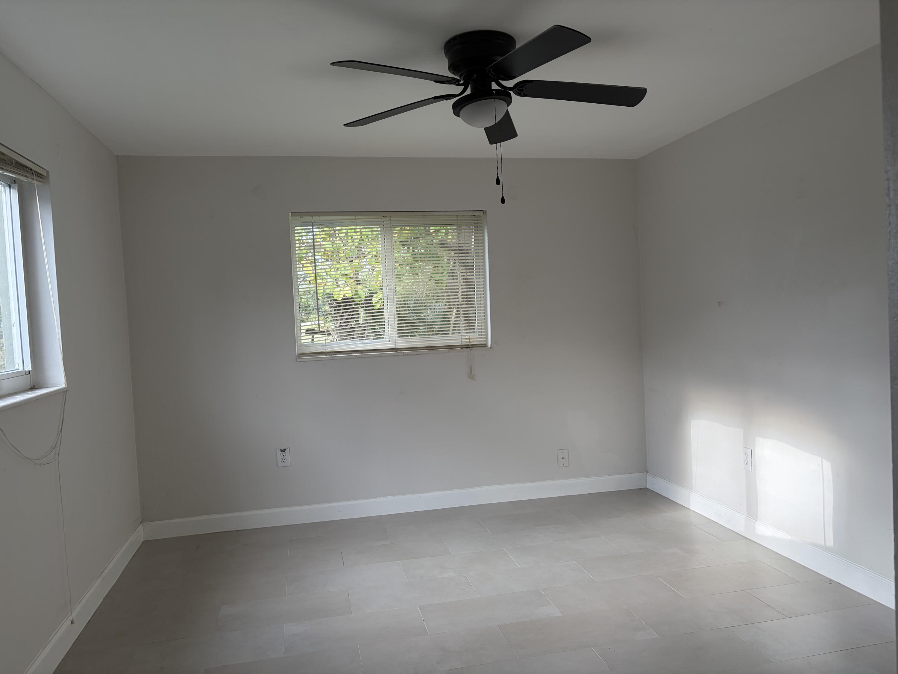 6691 Northwest 30th Street Sunrise, FL 33313 - Photo 15 of 26 an empty room with windows and ceiling fan