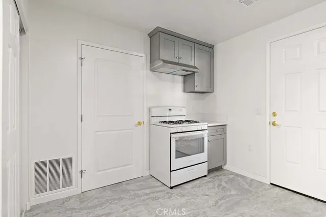 a kitchen with a white stove top oven and white cabinets
