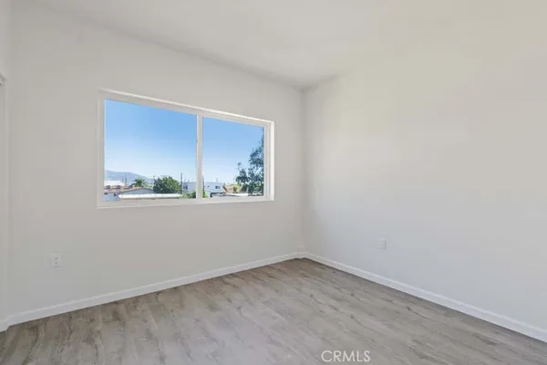a view of a small space with wooden floor and a window