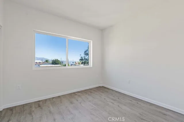 a view of a small space with wooden floor and a window
