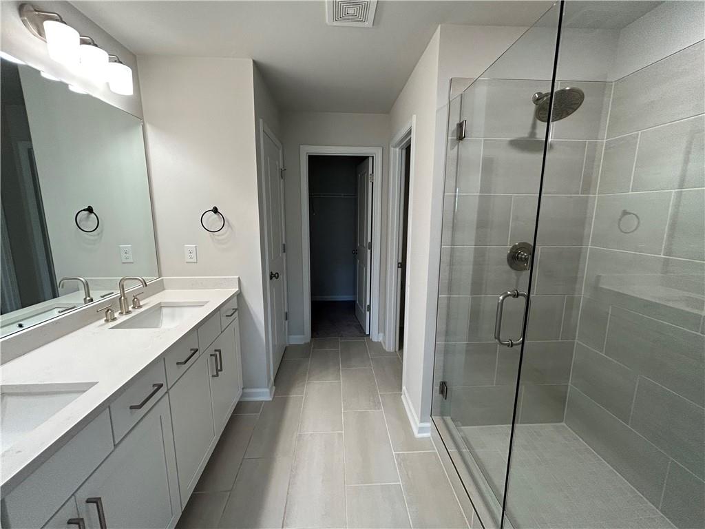 3715 Davis Circle Duluth, GA 30096 - Photo 17 of 20 a bathroom with a double vanity sink a mirror and a shower