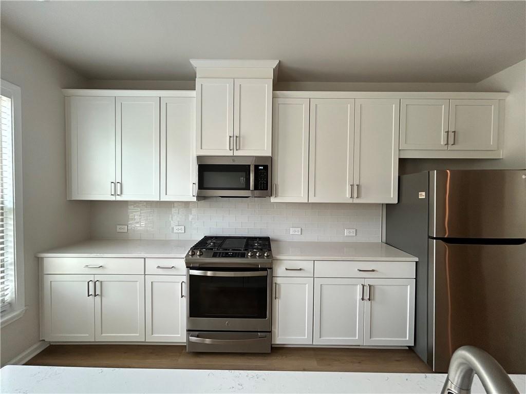 3715 Davis Circle Duluth, GA 30096 - Photo 3 of 20 a kitchen with white cabinets and white appliances