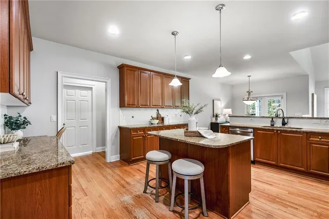a kitchen with granite countertop kitchen island wooden cabinets and refrigerator