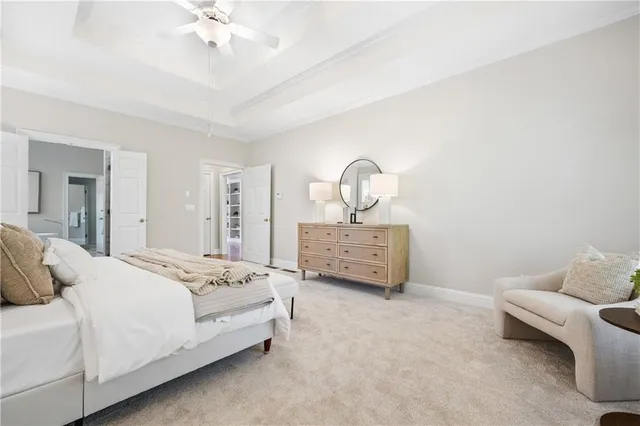 a spacious bedroom with a bed a couch and chandelier