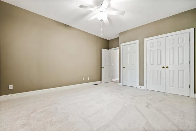 an empty room with chandelier fan
