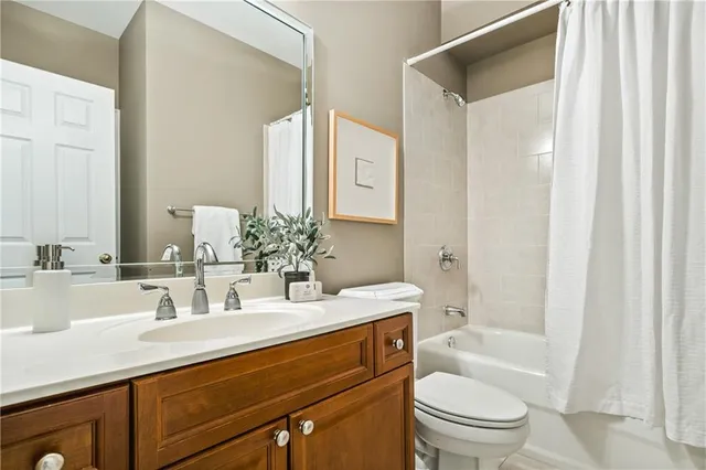 a bathroom with a sink a toilet and a large mirror