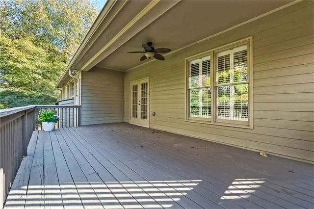 a view of backyard with wooden deck and floor to ceiling window
