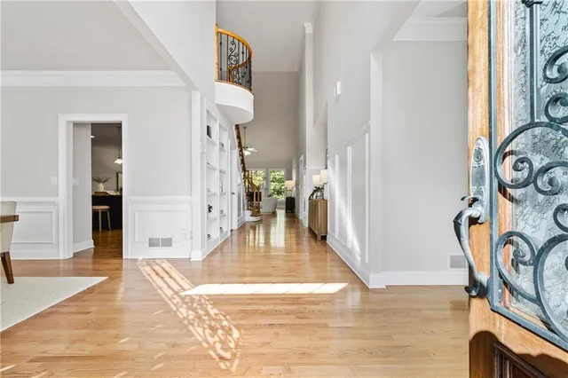 a view of a hallway with wooden floor and a living room