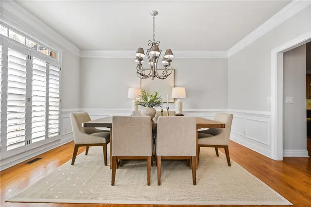 a dining room with furniture potted plants and wooden floor