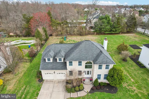an aerial view of a house with a garden and lake view