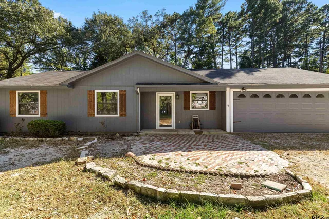 a view of house with backyard and trees around