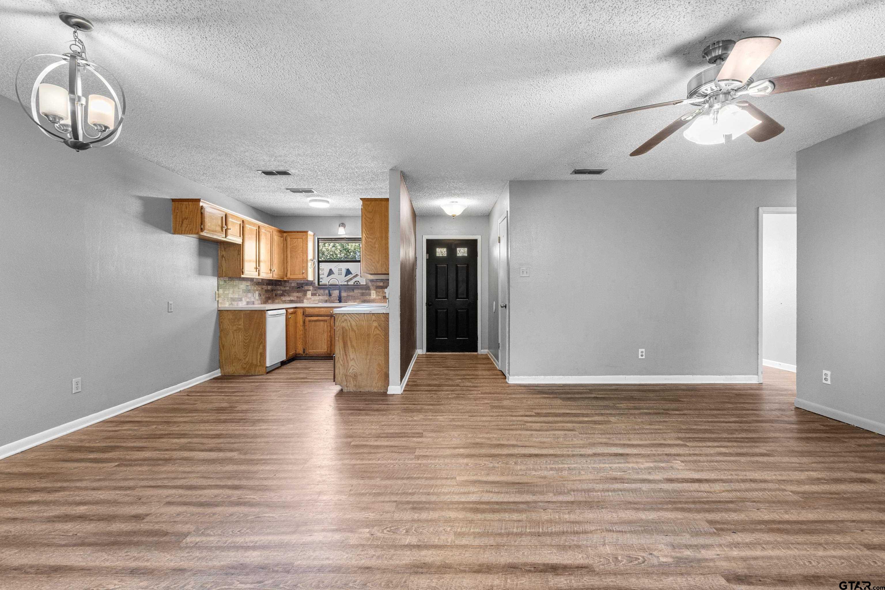 473 Meadow View Path Holly Lake Ranch, TX 75765 - Photo 14 of 37 a view of kitchen and empty room with wooden floor
