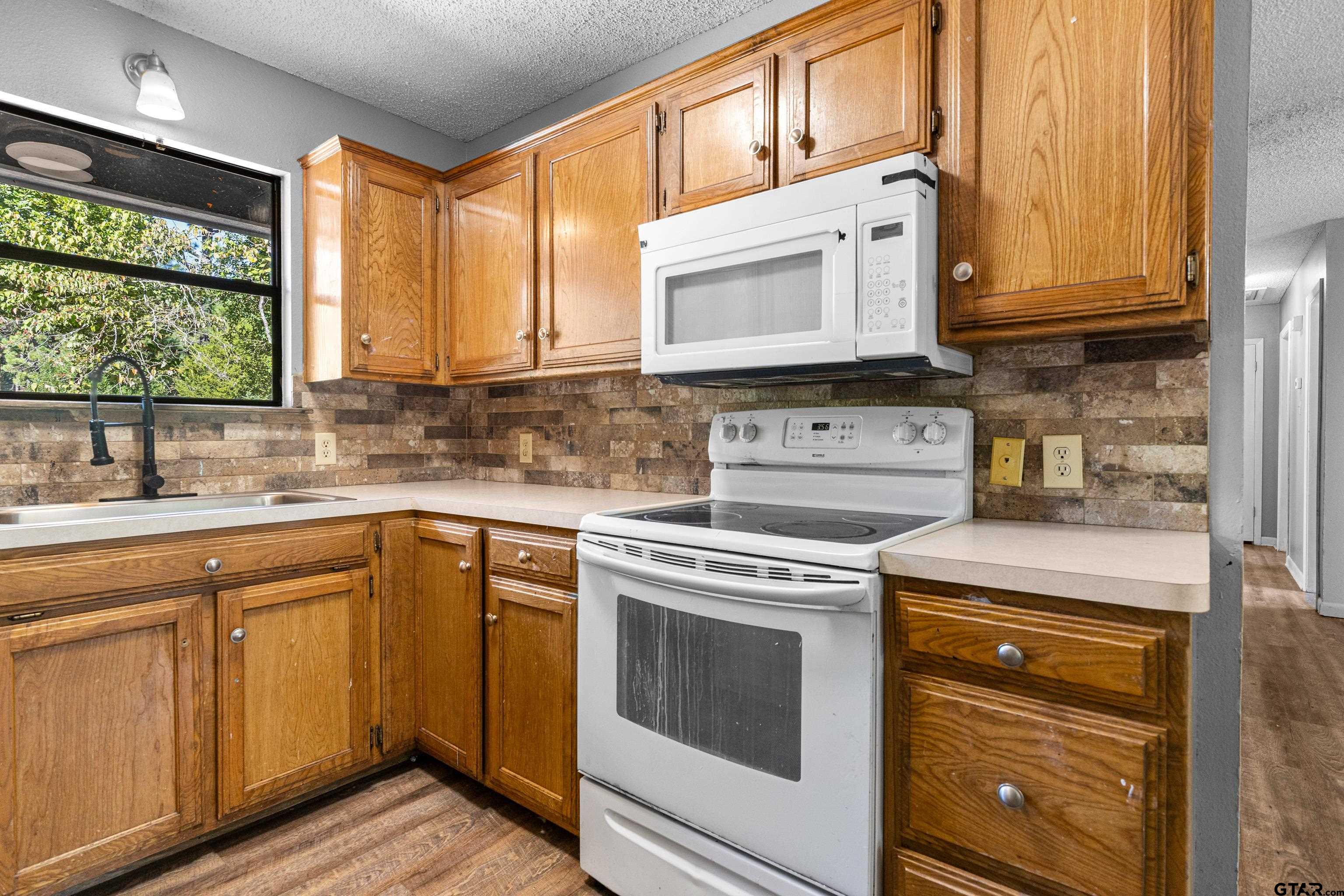 473 Meadow View Path Holly Lake Ranch, TX 75765 - Photo 18 of 37 a kitchen with stainless steel appliances granite countertop wooden cabinets stove top oven and sink
