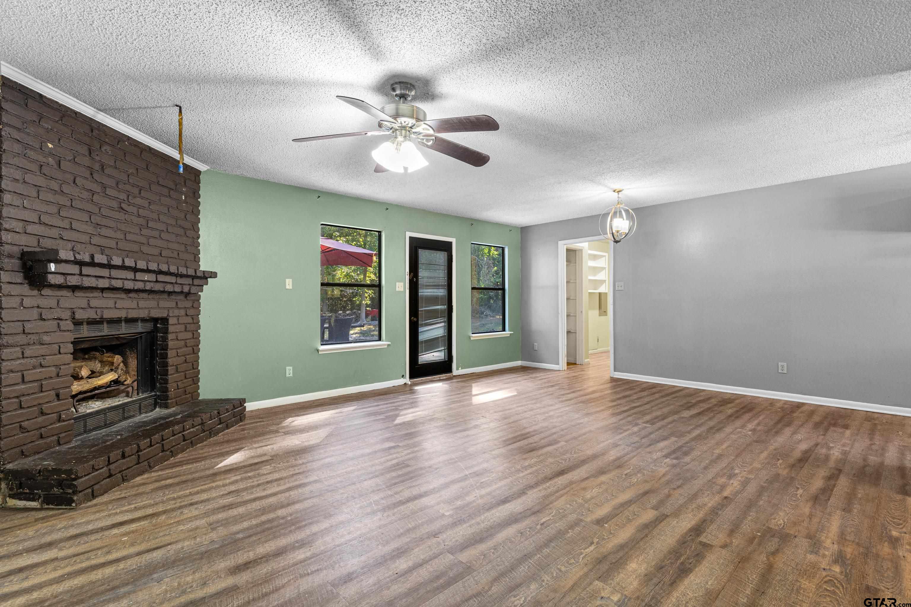 473 Meadow View Path Holly Lake Ranch, TX 75765 - Photo 20 of 37 a view of an empty room with wooden floor fireplace and a window