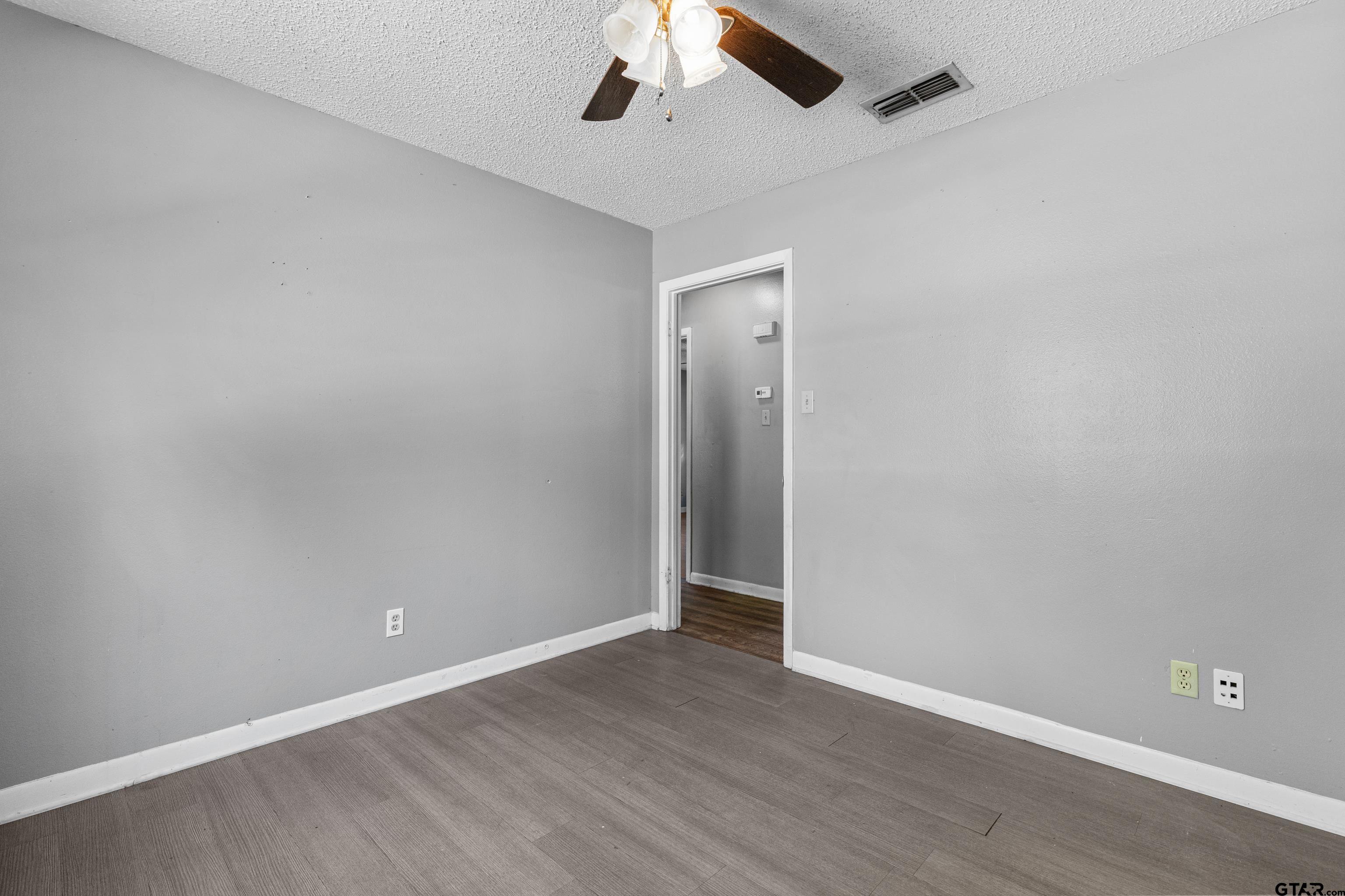473 Meadow View Path Holly Lake Ranch, TX 75765 - Photo 25 of 37 an empty room with a ceiling fan and wooden floor