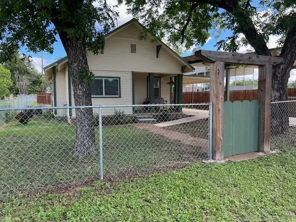 a view of a house with a yard and large tree