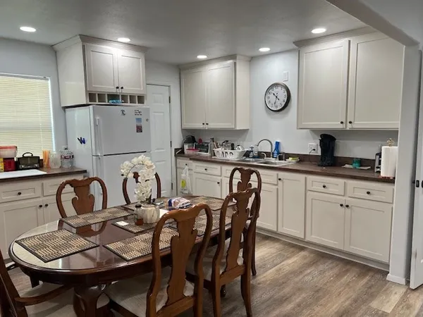 a kitchen with granite countertop a refrigerator a sink a stove a microwave and cabinets