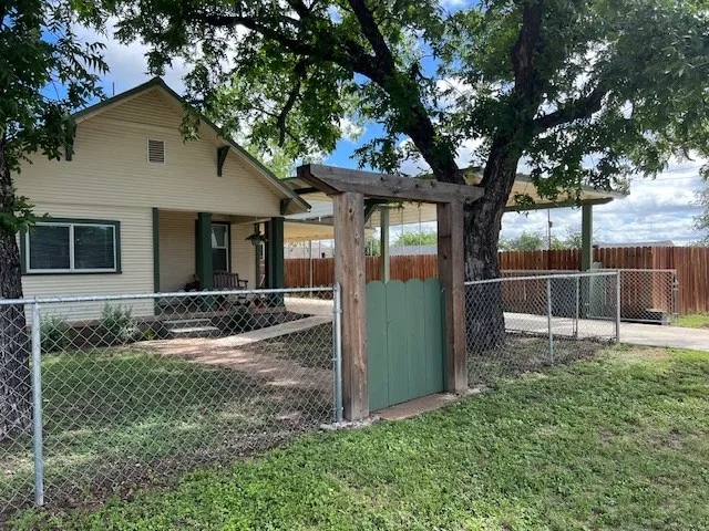 a view of a house with backyard and a tree