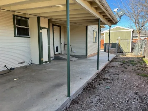 a view of a patio with a table and chairs under an umbrella