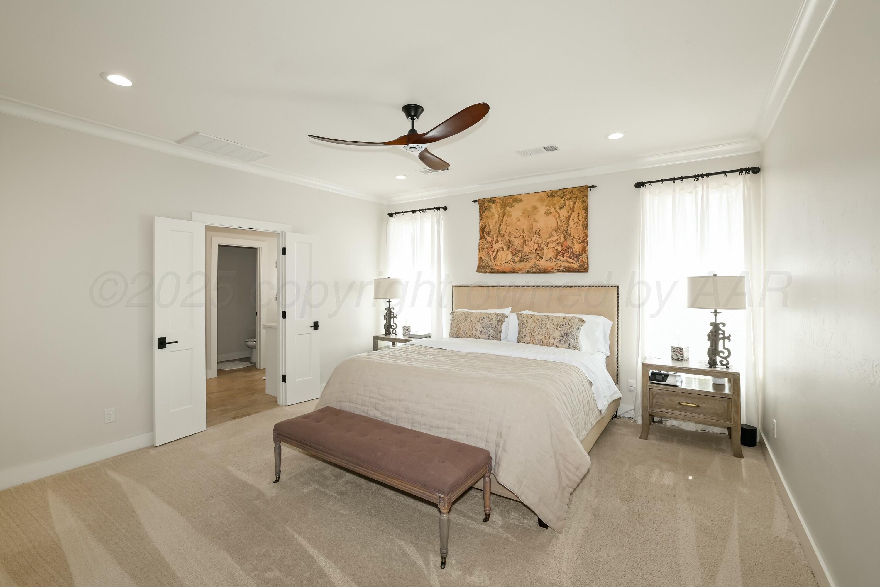 19081 Elk Springs Road Amarillo, TX 79119 - Photo 20 of 41 a spacious bedroom with a bed and a painting on the wall