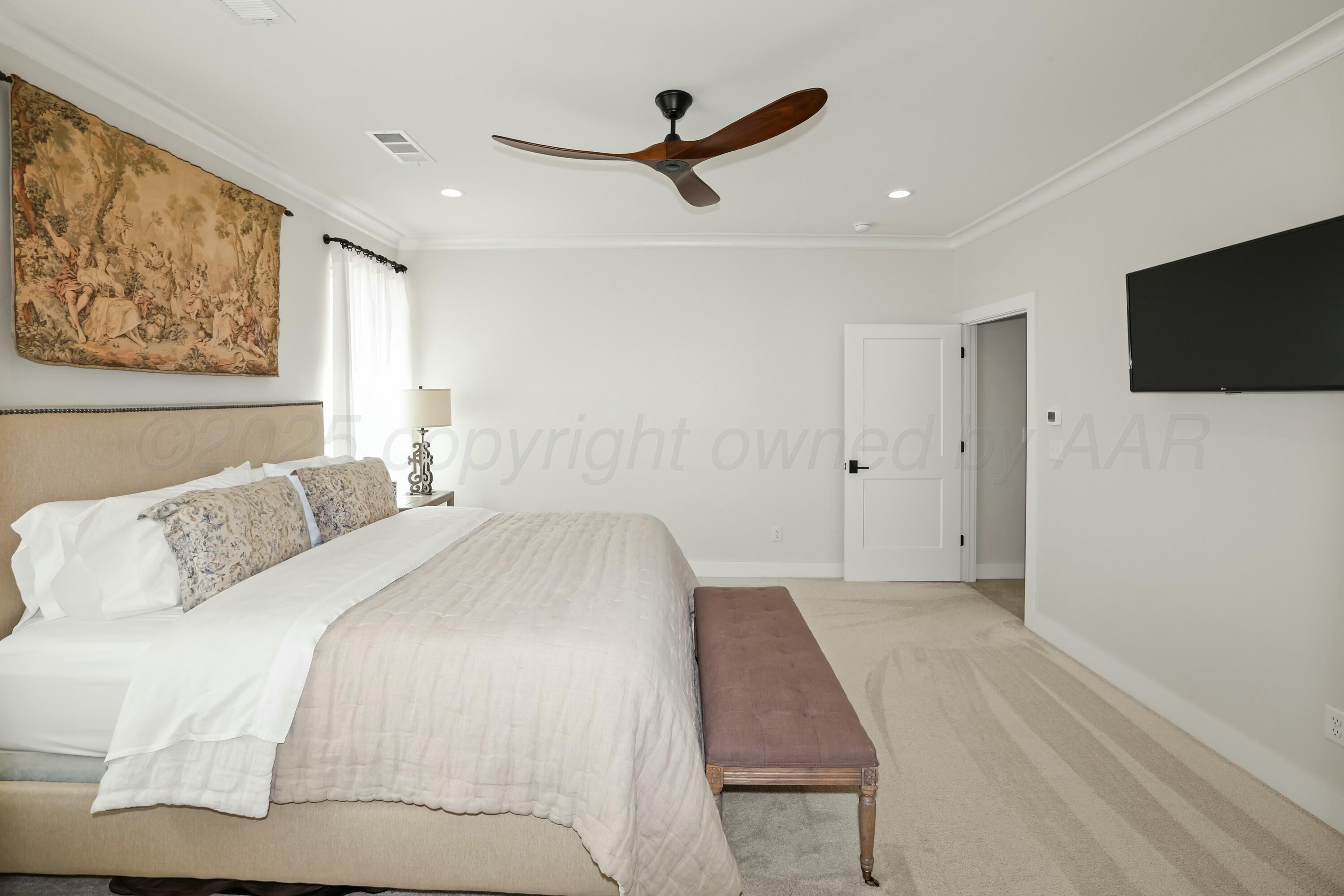 19081 Elk Springs Road Amarillo, TX 79119 - Photo 21 of 41 a bedroom with a large bed and a ceiling fan
