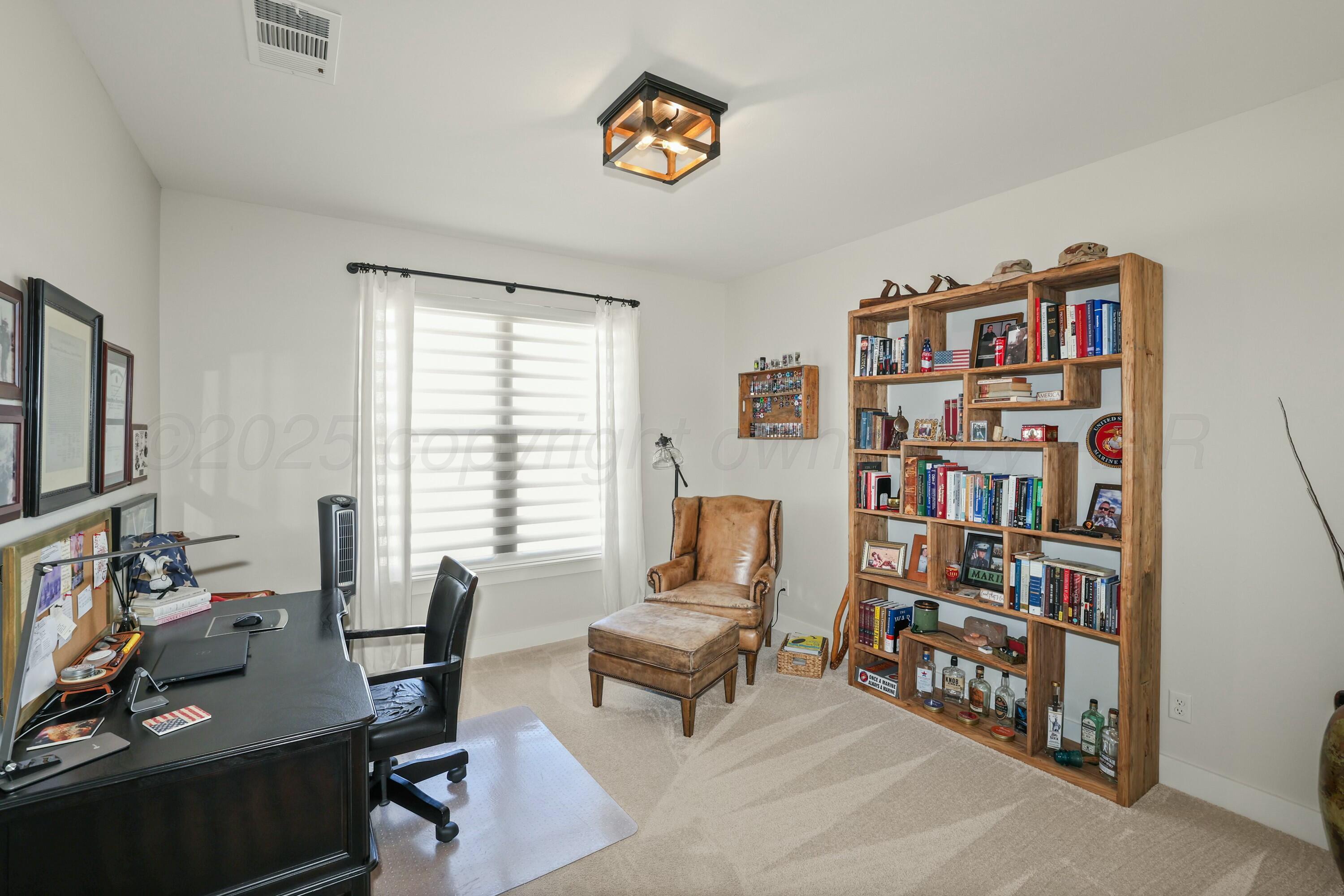 19081 Elk Springs Road Amarillo, TX 79119 - Photo 27 of 41 a living room with furniture a bookshelf and a window