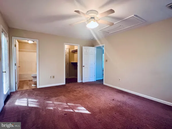 a view of a bedroom with closet and a ceiling fan