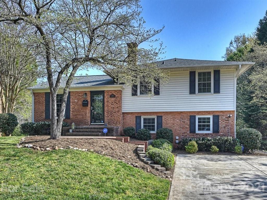 front view of a brick house with a yard