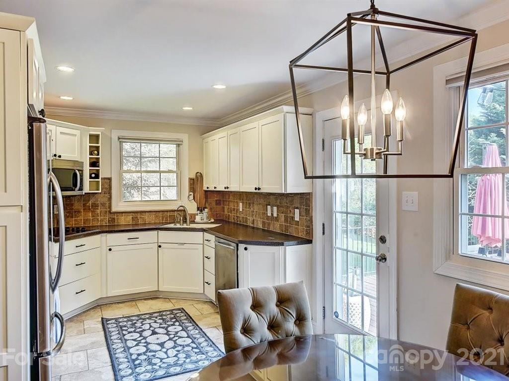 5121 Murrayhill Road Charlotte, NC 28210 - Photo 12 of 47 a kitchen with granite countertop a refrigerator a sink and white cabinets