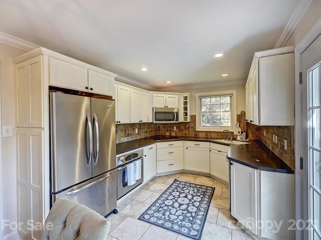 5121 Murrayhill Road Charlotte, NC 28210 - Photo 15 of 47 a kitchen with a refrigerator a sink and cabinets