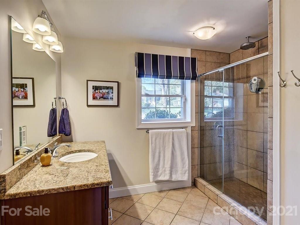 5121 Murrayhill Road Charlotte, NC 28210 - Photo 30 of 47 a bathroom with a granite countertop sink a mirror and shower