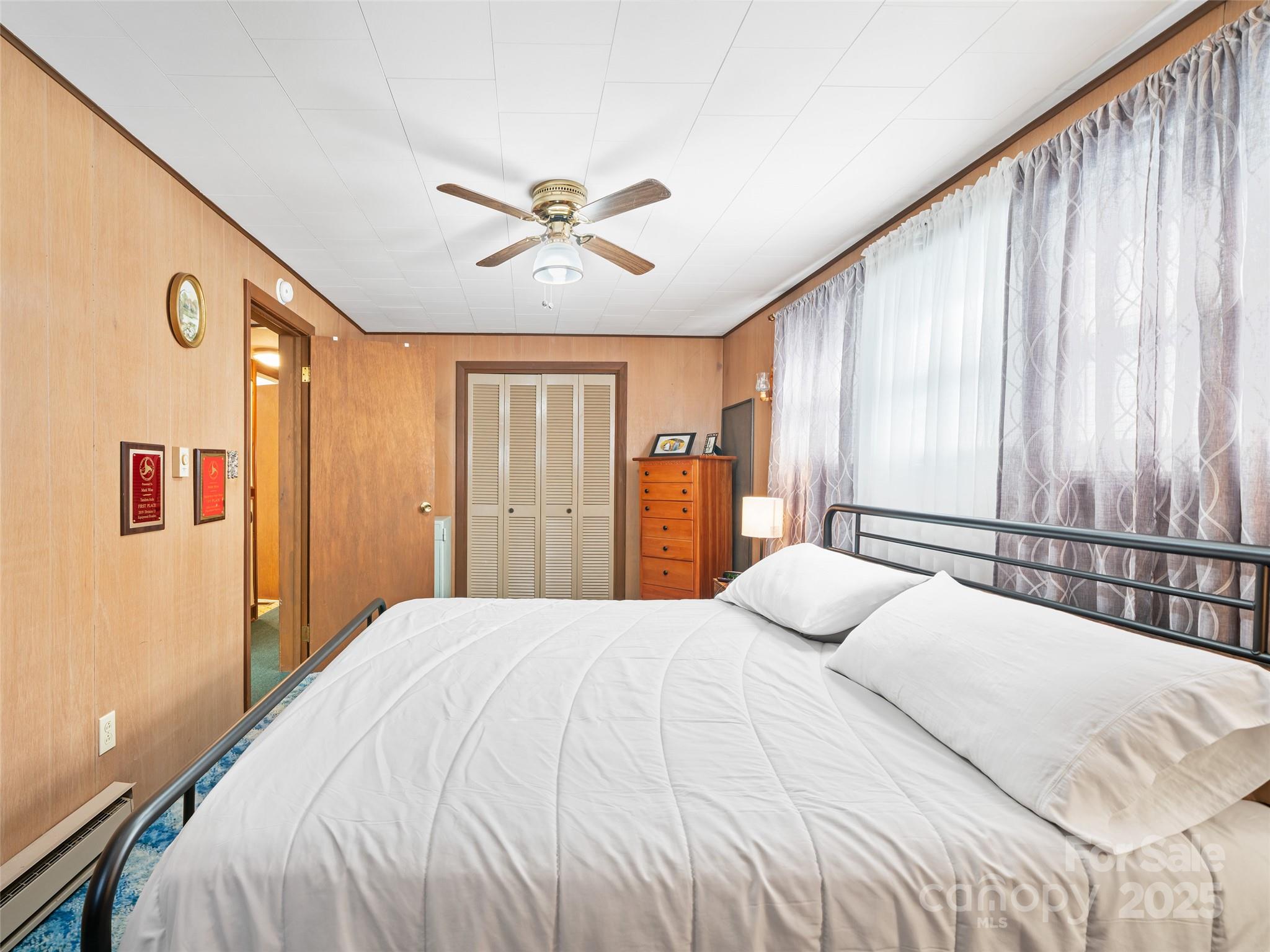 2850 Henson Creek Road Newland, NC 28657 - Photo 13 of 27 a bedroom with a large bed and a chandelier