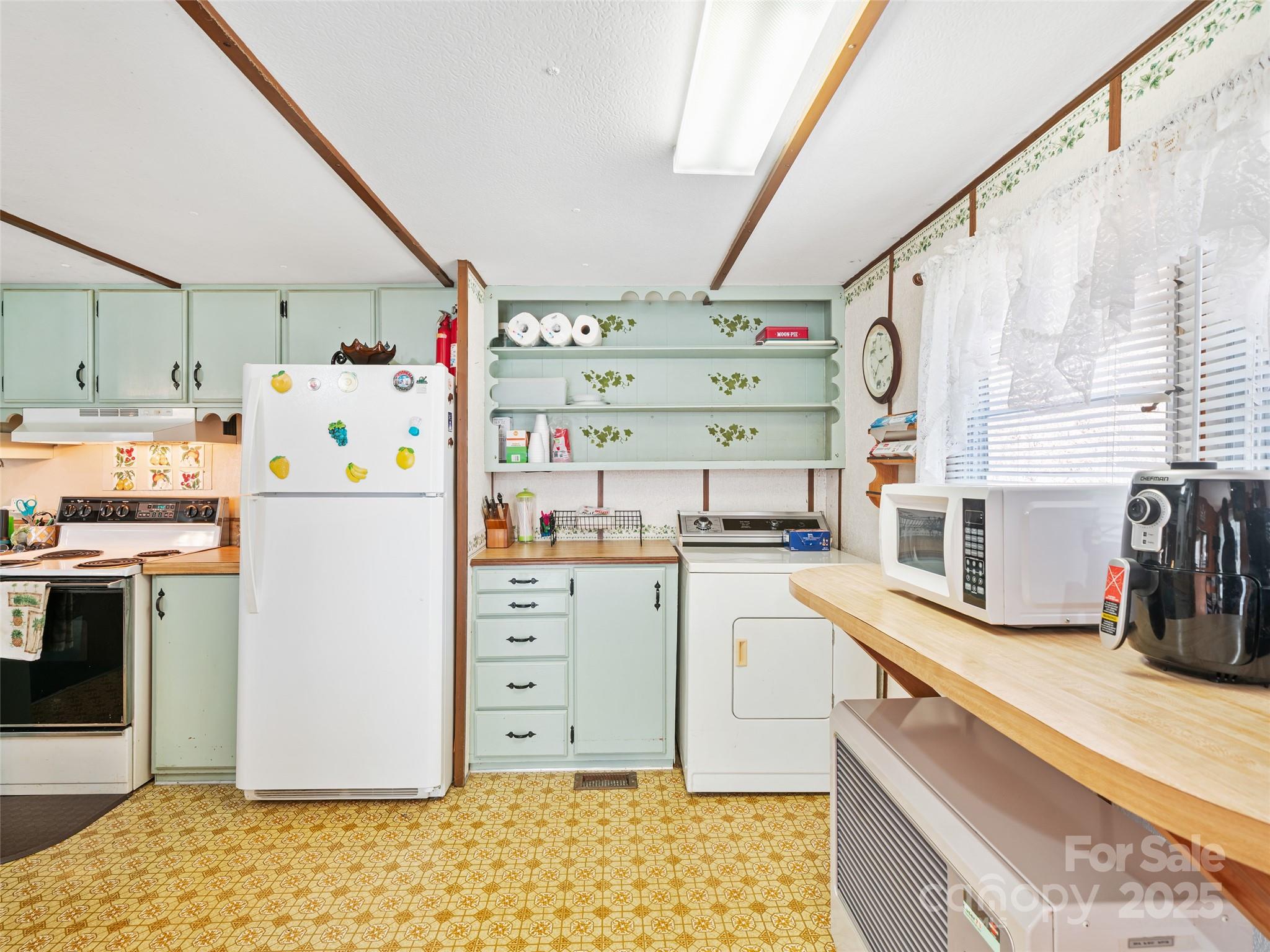 2850 Henson Creek Road Newland, NC 28657 - Photo 9 of 27 a kitchen with a refrigerator and white cabinets