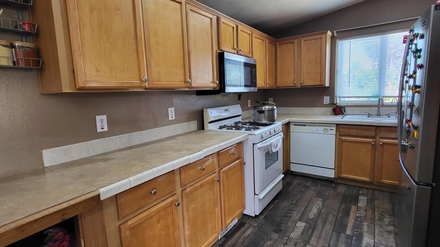 501 South Green Valley Road, Unit 89 Watsonville, CA 95076 - Photo 3 of 12 a kitchen with stainless steel appliances granite countertop a sink stove and microwave