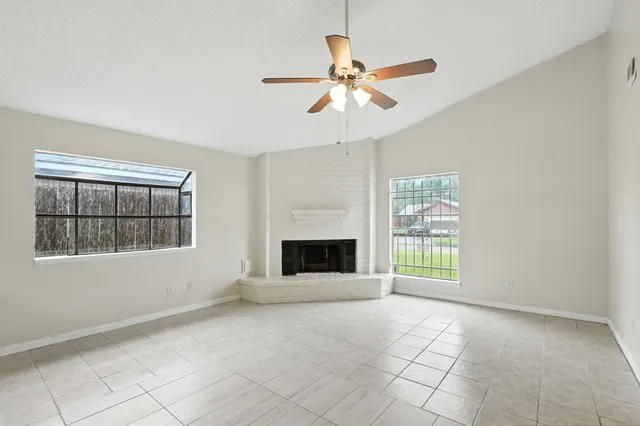 a view of an empty room with a window and fireplace